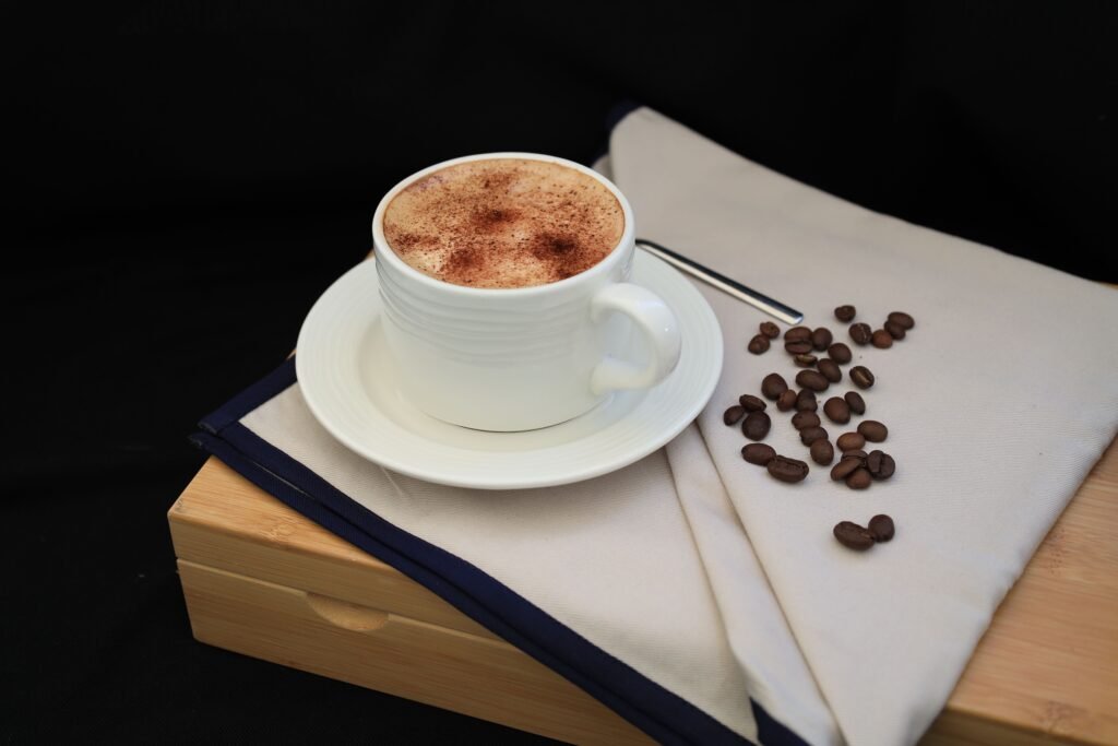 A warm cappuccino on a napkin with coffee beans, perfect for coffee lovers.